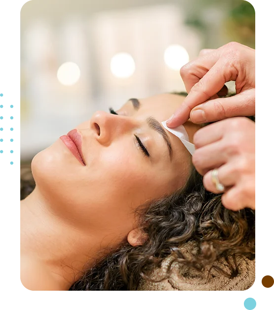 Woman receiving eyebrow waxing treatment.